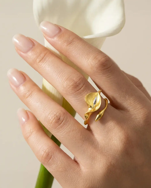 Bague arum en argent 925 finition dorée portée à la main dans une ambiance naturelle et élégante.