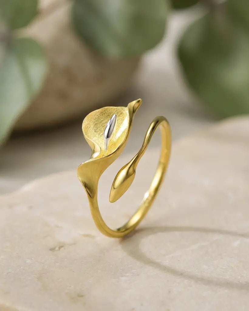 Bague arum en argent 925 avec finition dorée posée dans une mise en scène végétale douce et naturelle.