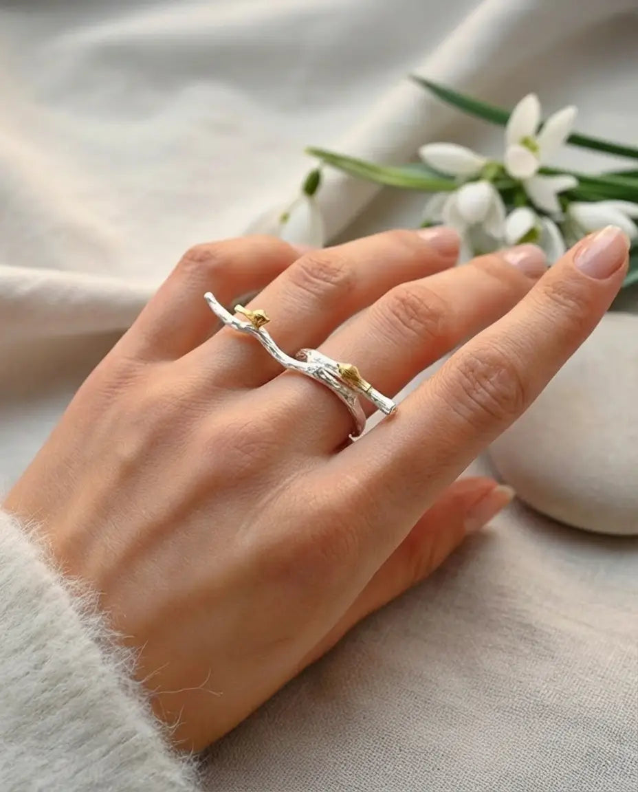 Bague brache en argent 925 portée sur une main de femme, ambiance florale, lifestyle premium.