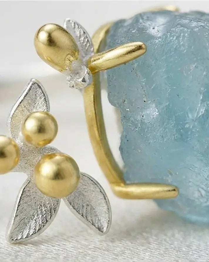 Gros plan sur l’aquamarine brute de la Bague de l’Eau, révélant la texture naturelle du cristal et les finitions en argent 925.