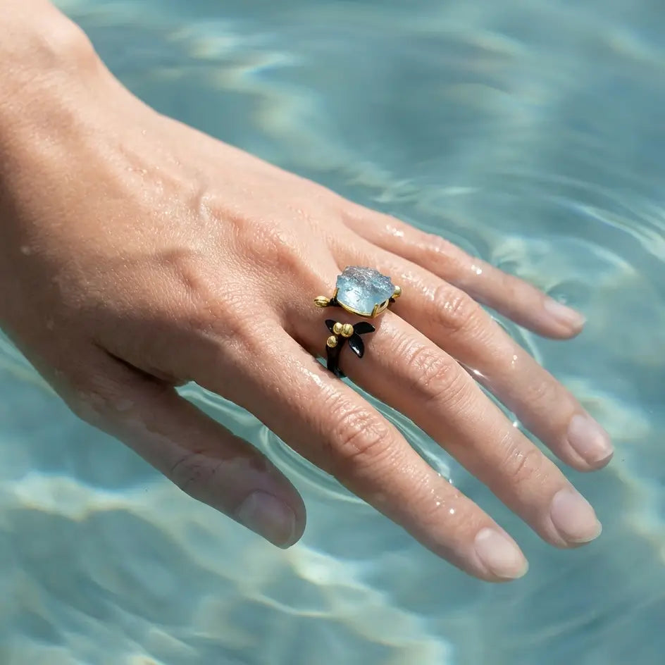 Bague de l’Eau en argent 925 portée sur une main immergée dans l’eau claire, avec reflets naturels et lumière solaire.