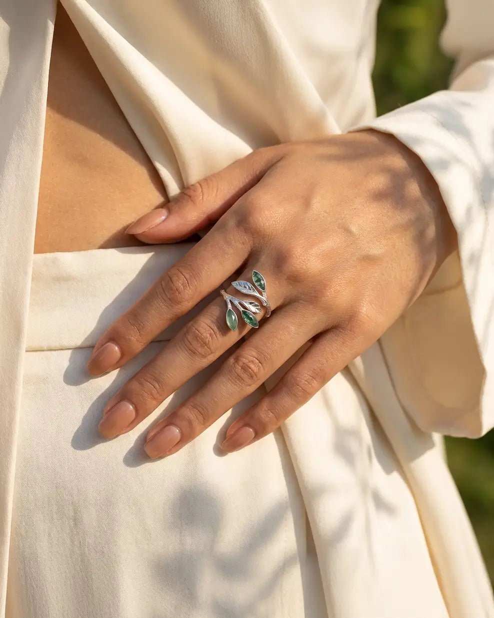 Bague feuillage argent 925 et aventurine verte portée à la main, lumière naturelle et tenue claire, esprit végétal.