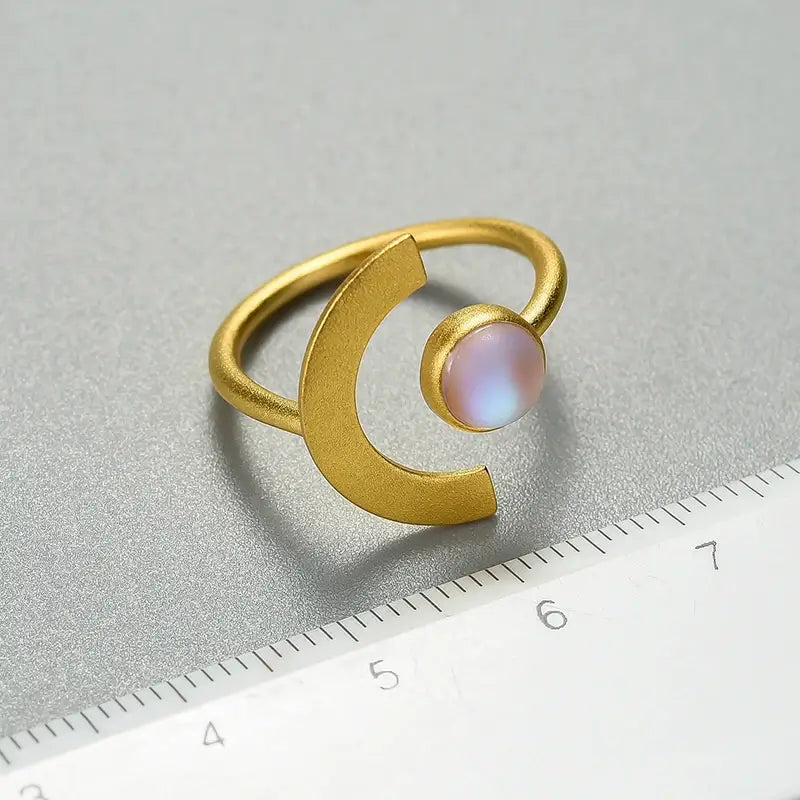 Bague Lune de Terre en argent 925 et émail glacé posée près d’une règle pour visualiser la taille et les proportions.