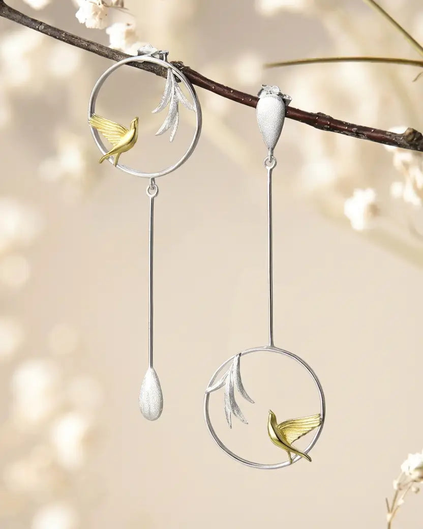 Boucles d’oreilles asymétriques Chant du Matin en argent 925 suspendues à une branche, évoquant la légèreté du matin.