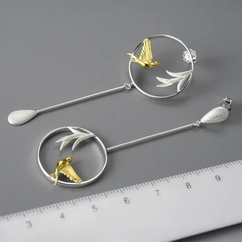 Boucles d’oreilles Chant du Matin en argent 925 posées près d’une règle pour visualiser leur taille réelle.