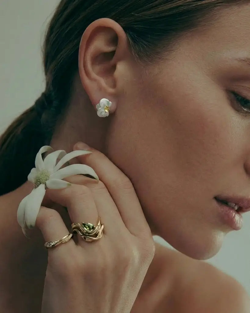 Boucles d’oreilles orchidées en argent 925 avec finition dorée portées par une femme, bijou floral et raffiné.