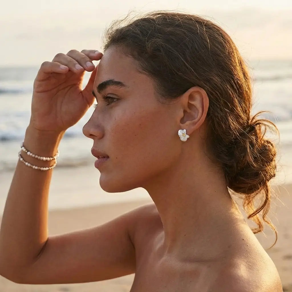 Boucles d’oreilles orchidées en argent 925 avec finition dorée portées par une femme en extérieur, style naturel et élégant.
