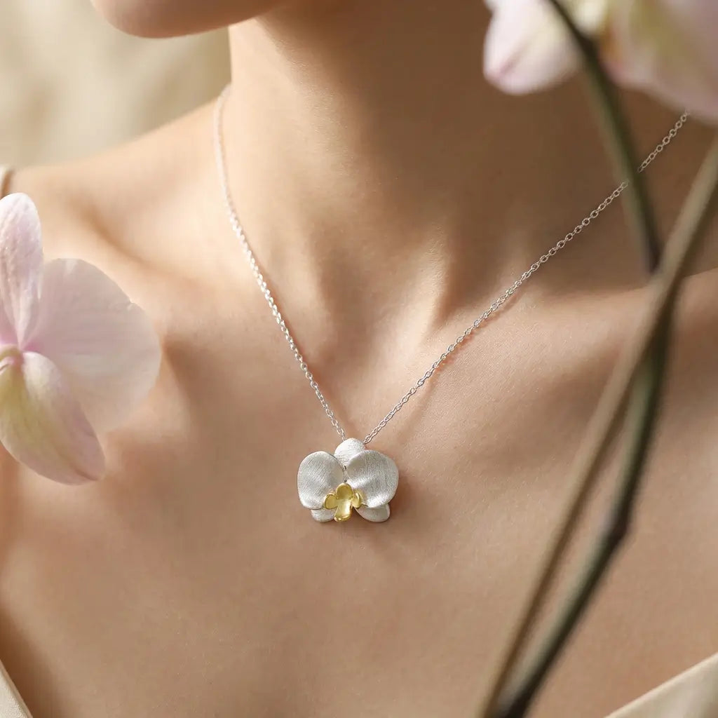 Collier orchidée en argent 925 porté par une femme, bijou floral délicat au style épuré.